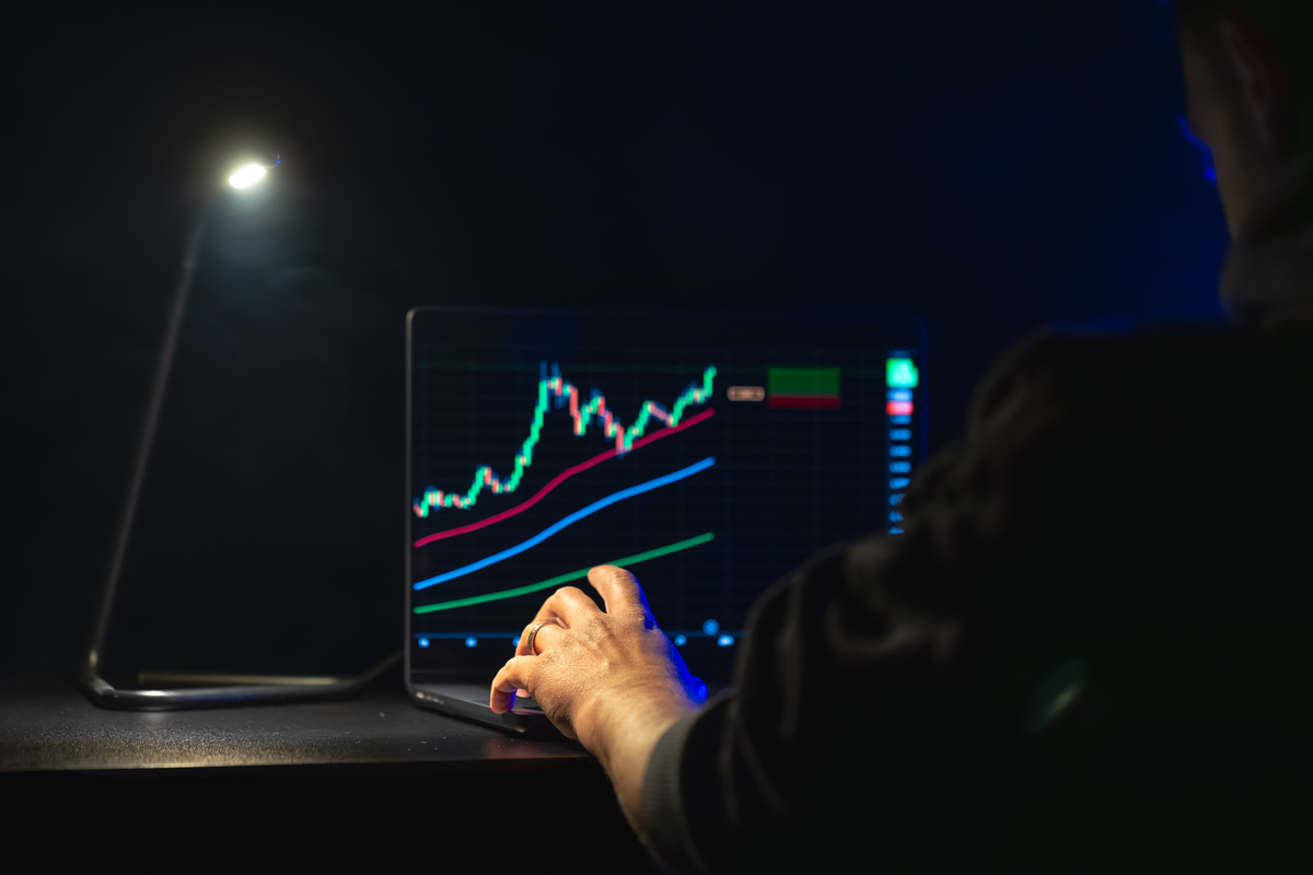 Trading stock. Stock market. Business graph. Trading investment. Broker. Stock exchange market. High quality photo. Hands on laptop, investments. The lamp shines in the dark.